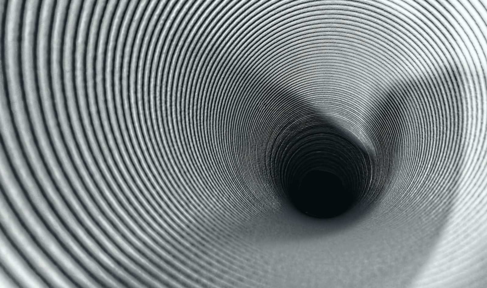 A narrowing tunnel converging from wide to a single point, evoking a pilot-to-production funnel