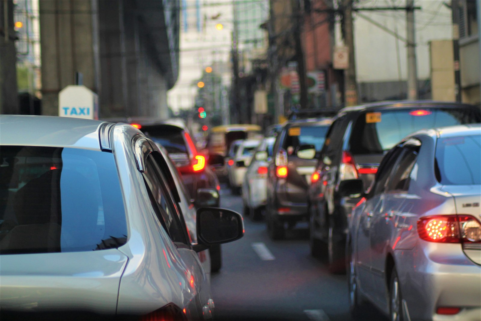 Bumper-to-bumper traffic on a city street, brake lights glowing