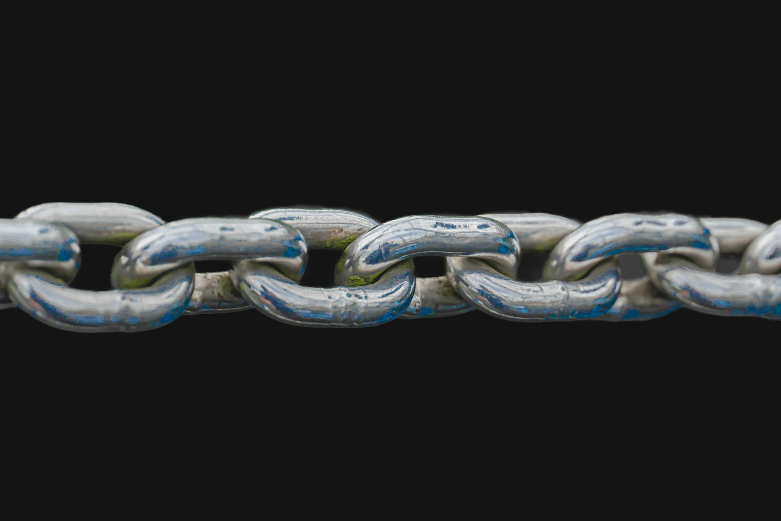 Chain links under tension against a dark background